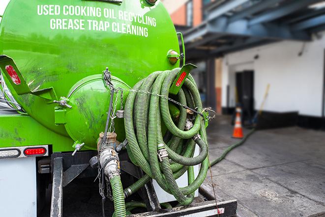 a grease trap pumping service in action at a commercial building in East Syracuse